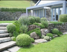 Luxury hillside villa outdoor lounge framed by shrubs and stone terraces